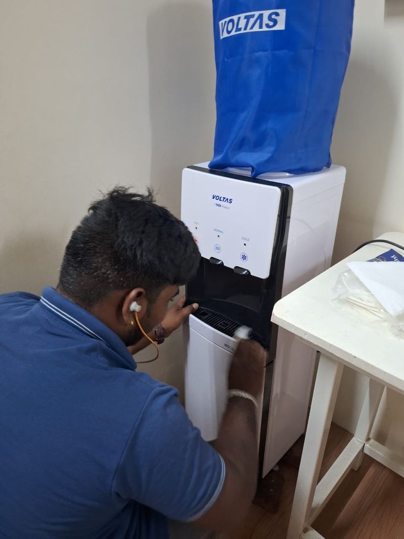 Universal Services technician repairing a water dispenser