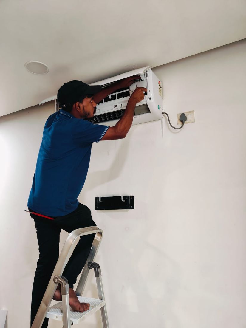 Universal Services technician repairing a wall-mounted split AC