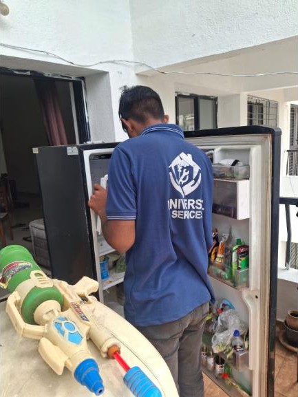 Universal Services technician servicing a refrigerator