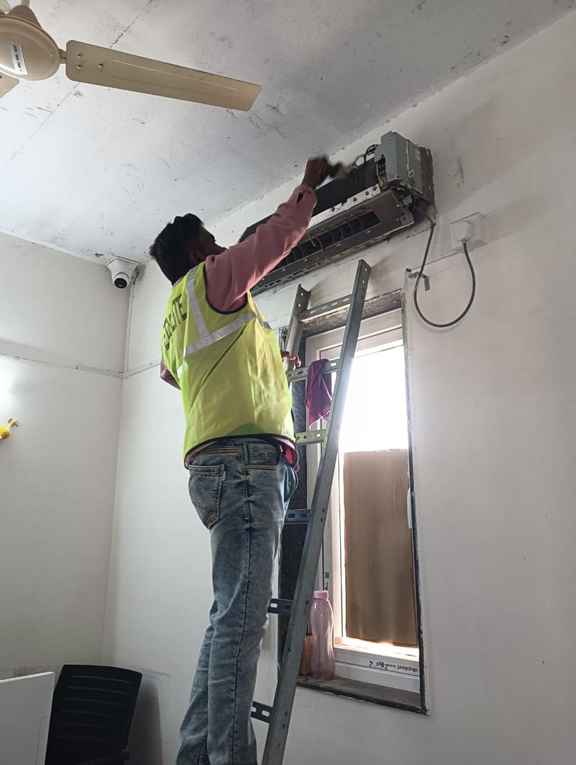 Universal Services technician cleaning a split AC indoor unit
