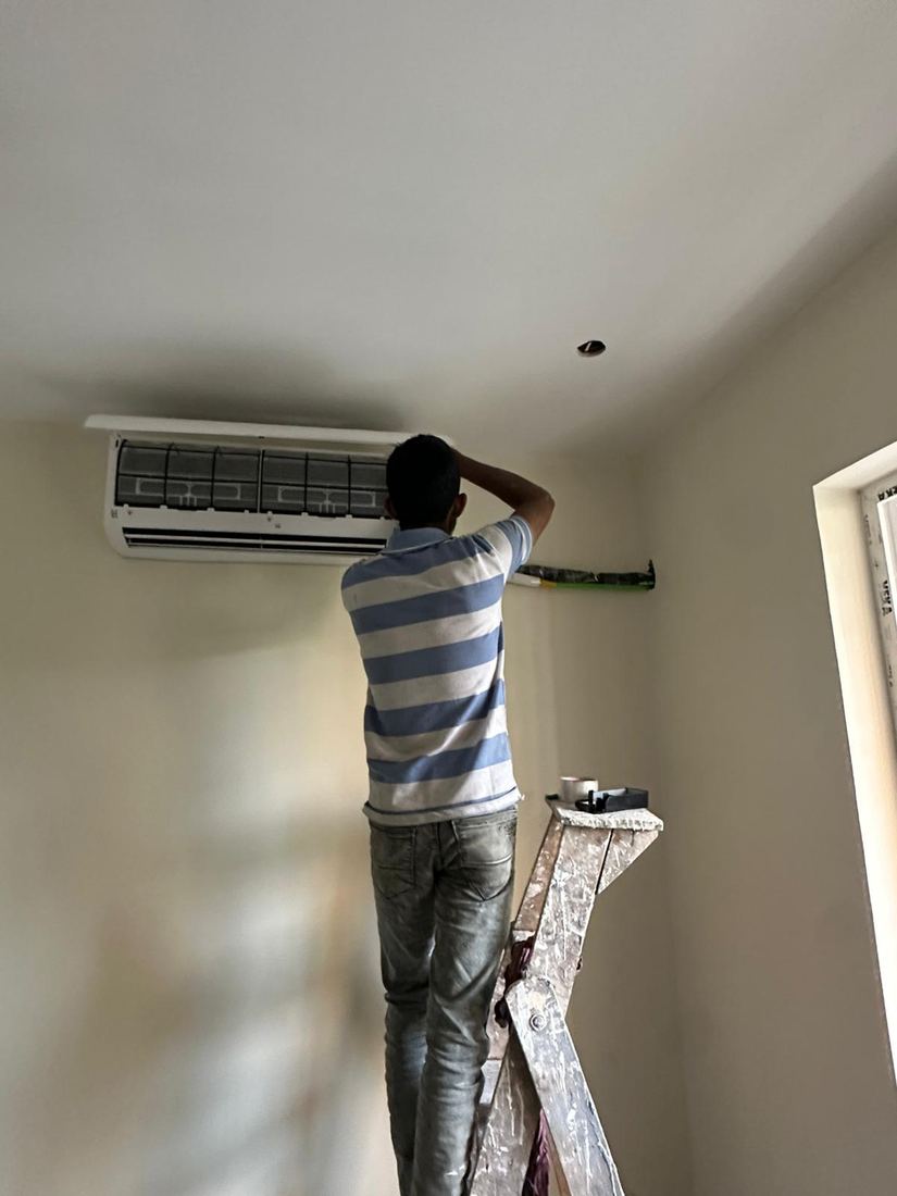 Universal Services technician servicing a wall-mounted split AC